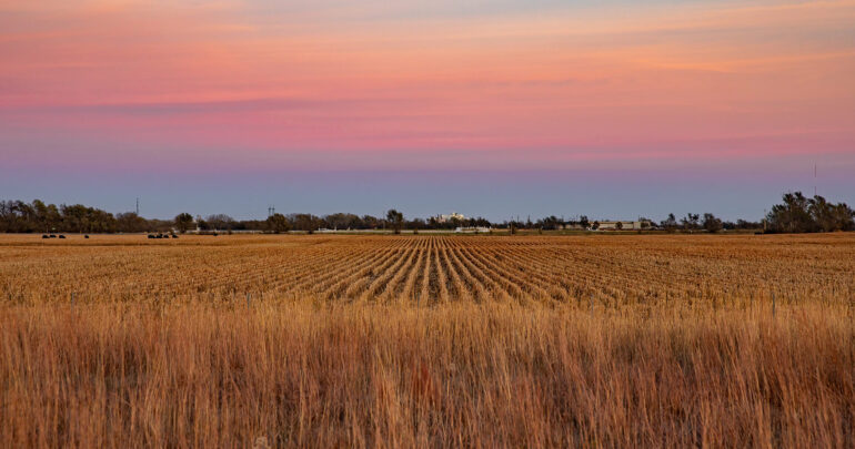 Landscape Of A Sunset Over A Dry Plowed Crop Field